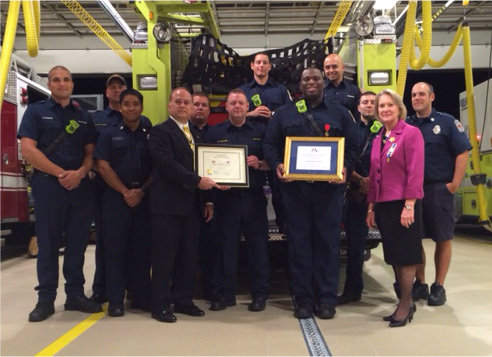 President Bill Price and DAR member Marsha Price present flag certificates to the staff of Fire Station 10